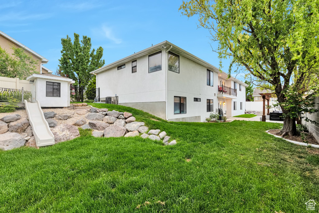 Rear view of house with a balcony and stucco siding