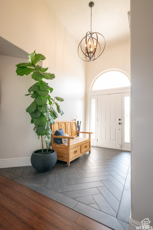 Entrance foyer with a chandelier, wood finished floors, and a high ceiling