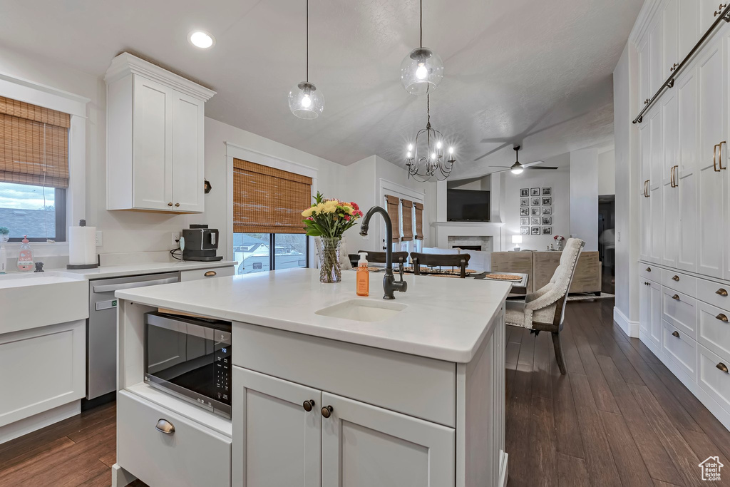 Kitchen with a sink, appliances with stainless steel finishes, a fireplace, healthy amount of natural light, and recessed lighting