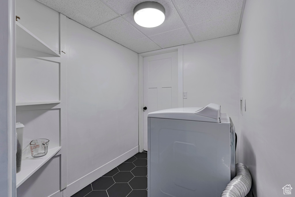 Washroom with washer / dryer and dark tile patterned floors