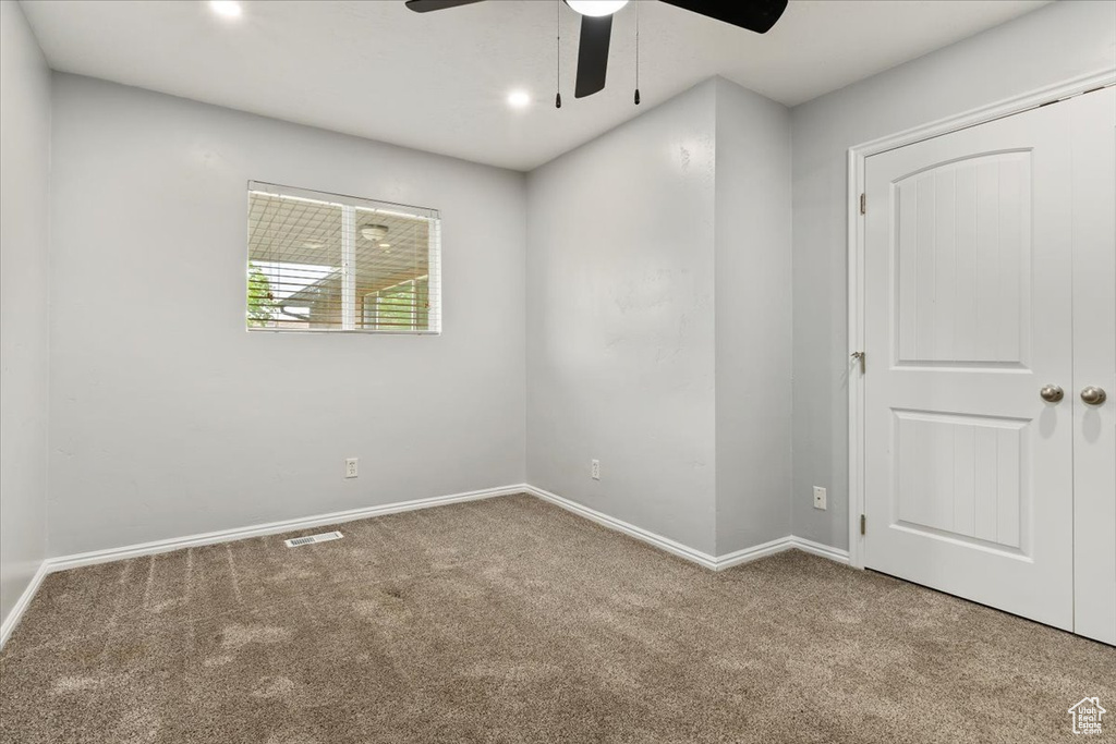 Carpeted empty room featuring a ceiling fan, baseboards, and recessed lighting
