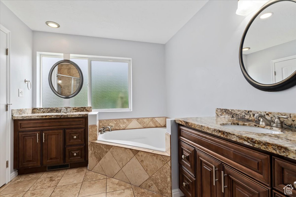 Bathroom featuring a garden tub and two vanities