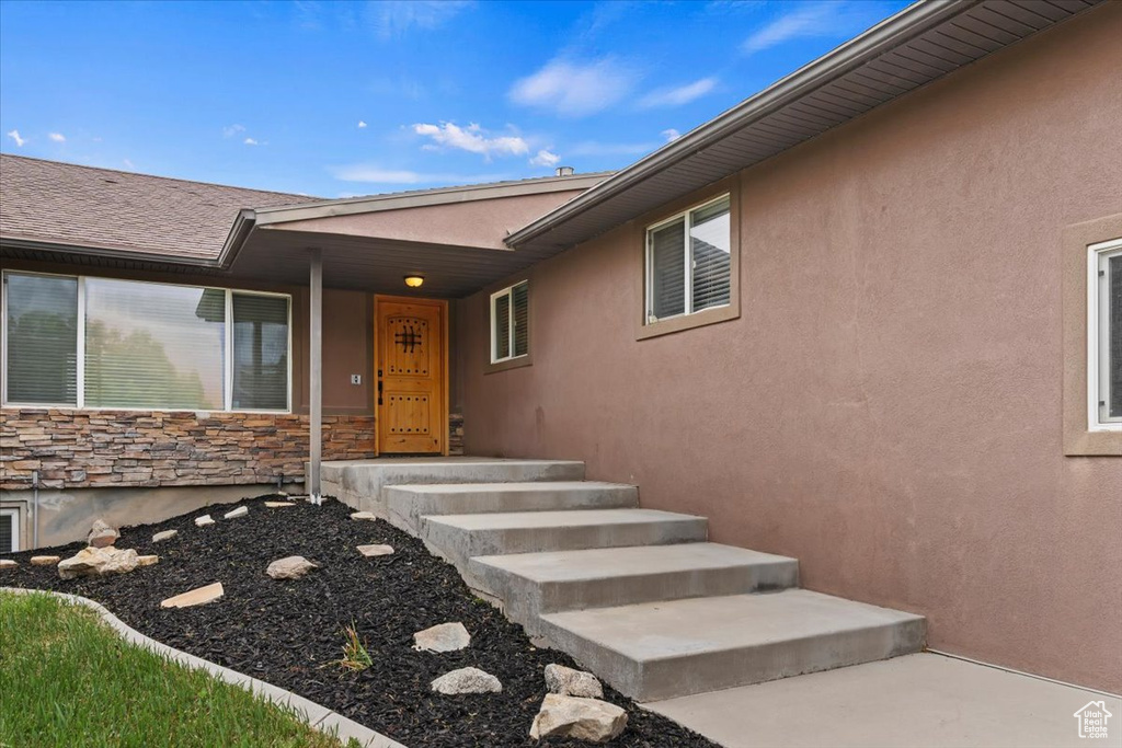 Property entrance featuring stone siding and stucco siding