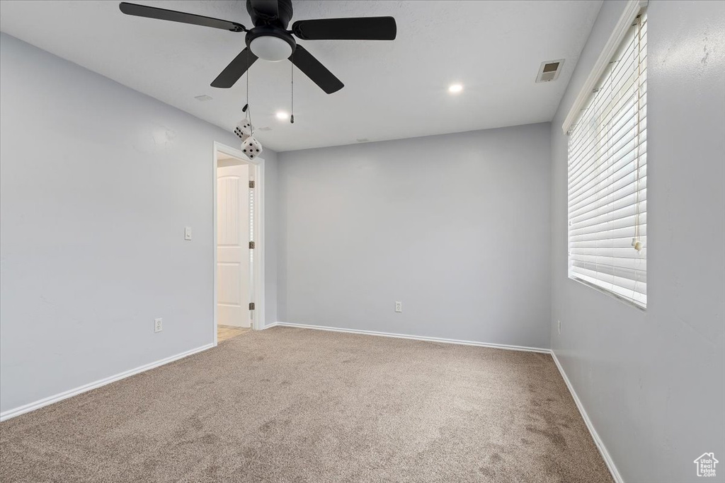 Carpeted empty room with a ceiling fan, baseboards, and recessed lighting