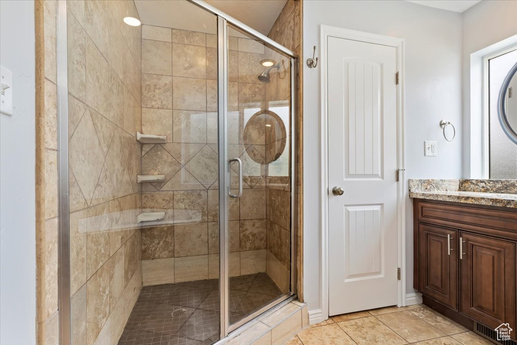 Bathroom featuring a shower stall, vanity, and tile patterned floors