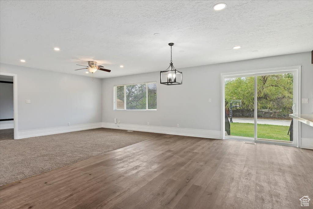 Unfurnished dining area featuring recessed lighting, wood finished floors, healthy amount of natural light, baseboards, and a textured ceiling