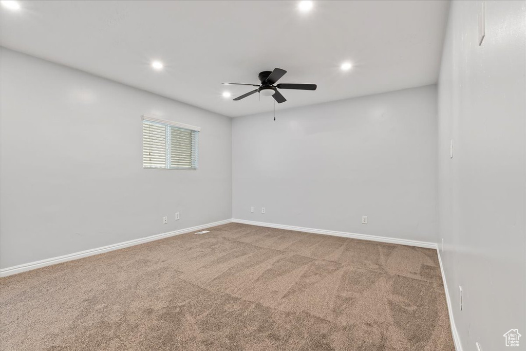 Carpeted empty room with a ceiling fan, baseboards, and recessed lighting