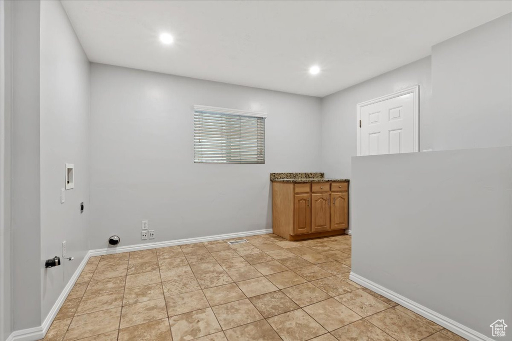 Washroom featuring hookup for an electric dryer, hookup for a washing machine, baseboards, recessed lighting, and cabinet space