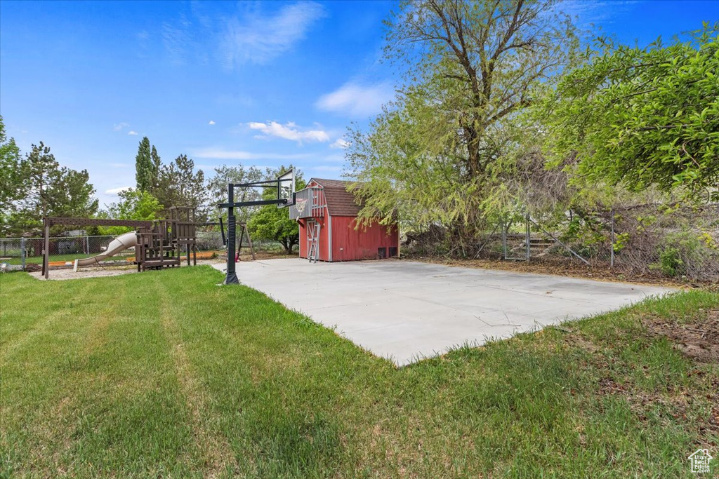 View of yard featuring a storage shed, a playground, and an outbuilding