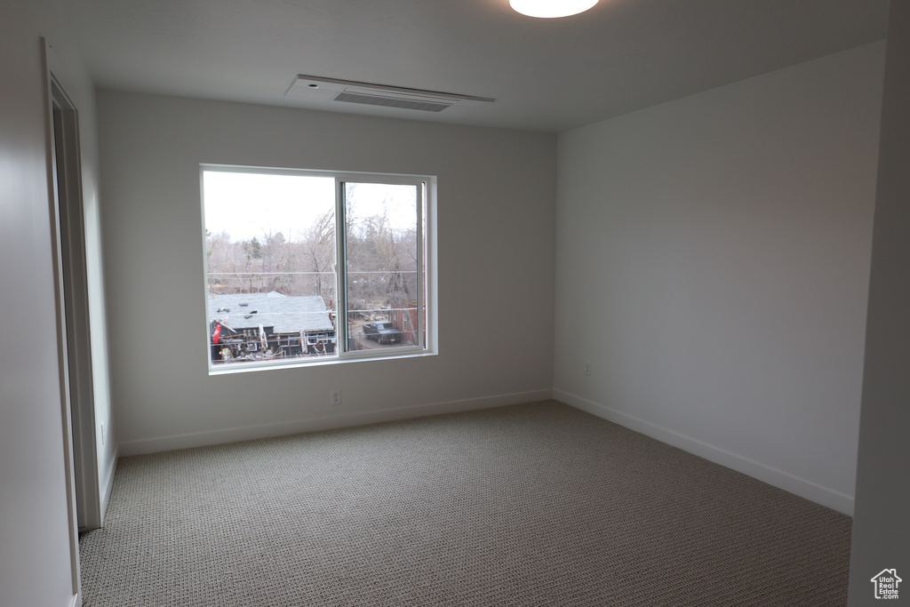 Carpeted empty room with baseboards
