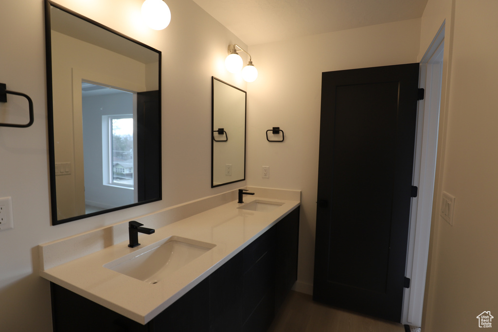 Bathroom featuring double vanity and wood finished floors