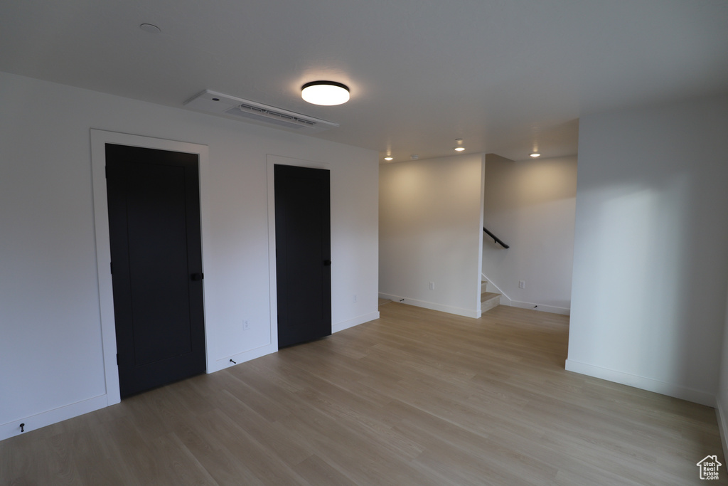 Unfurnished room with light wood-type flooring, stairway, recessed lighting, and baseboards