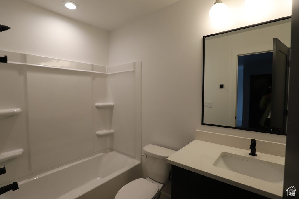 Full bathroom with vanity, toilet, washtub / shower combination, and recessed lighting