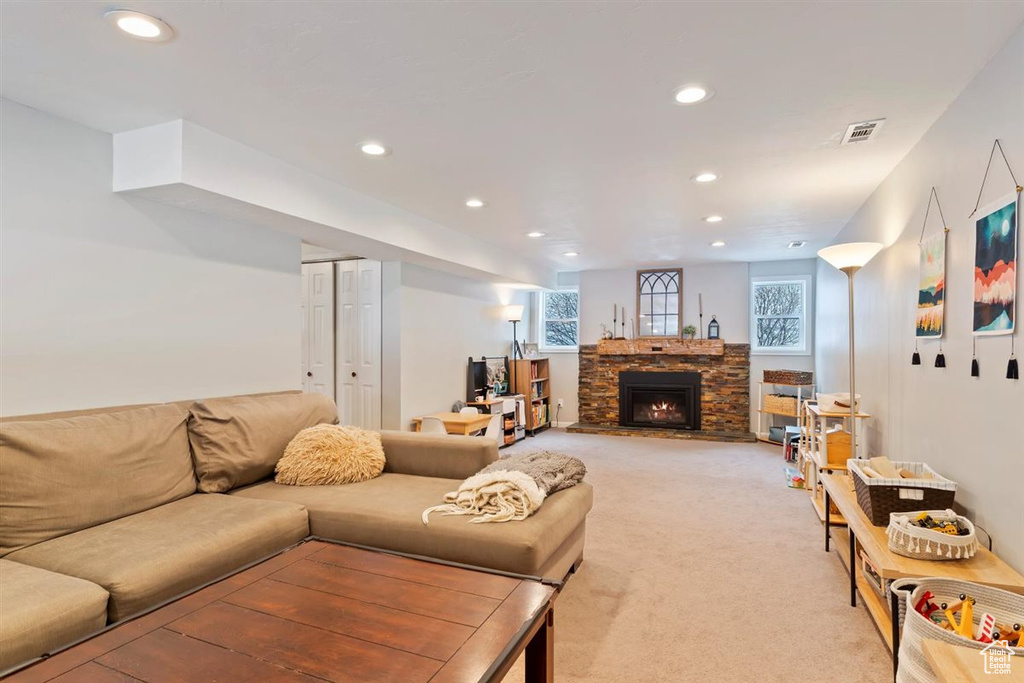 Living room featuring recessed lighting, light colored carpet, and a fireplace