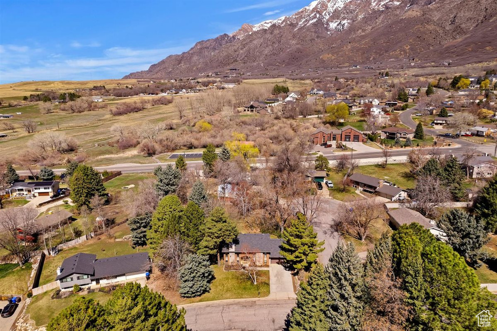 Aerial view of property and surrounding area with a mountainous background and nearby suburban area