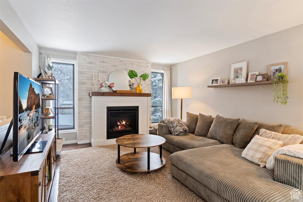 Living room with a brick fireplace and wood finished floors