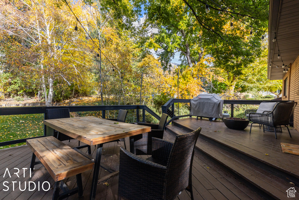 Wooden deck with outdoor dining area and a grill