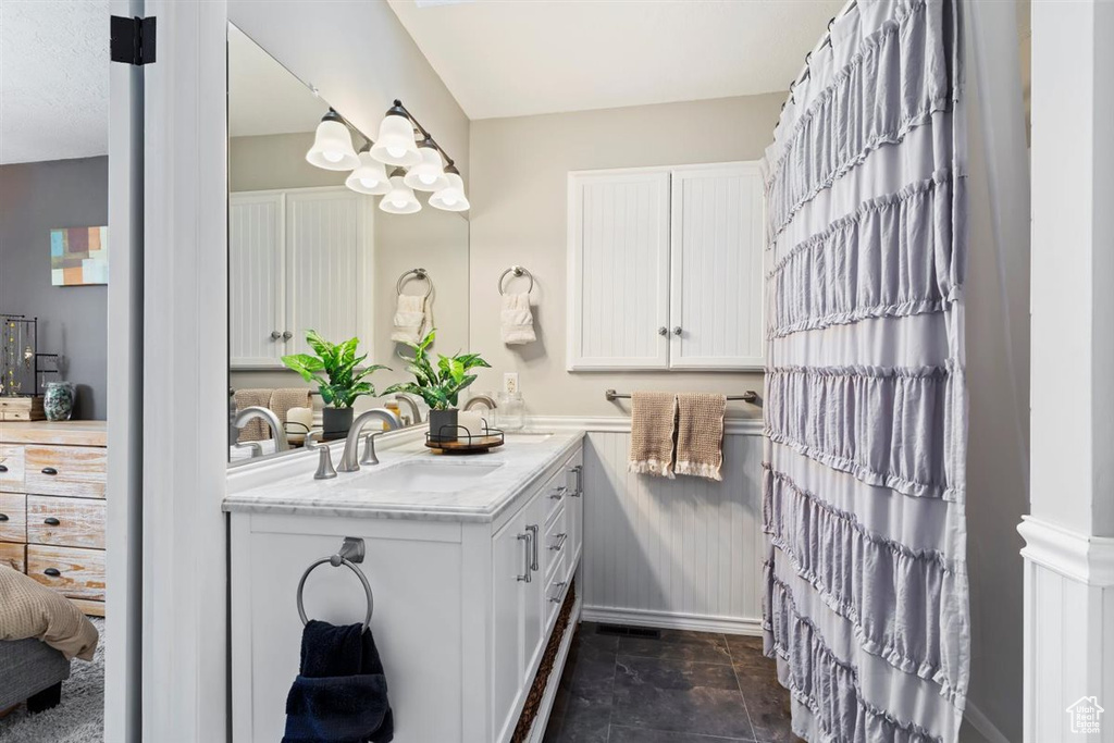 Full bathroom featuring double vanity and stone finish flooring