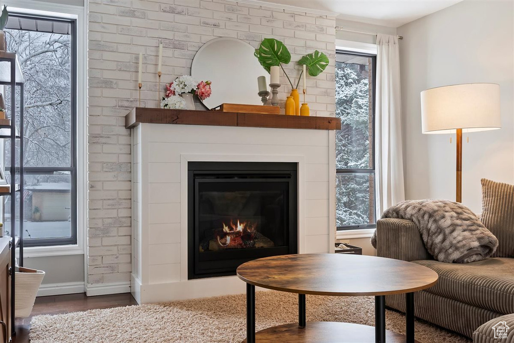 Living room with a fireplace, wood finished floors, and baseboards
