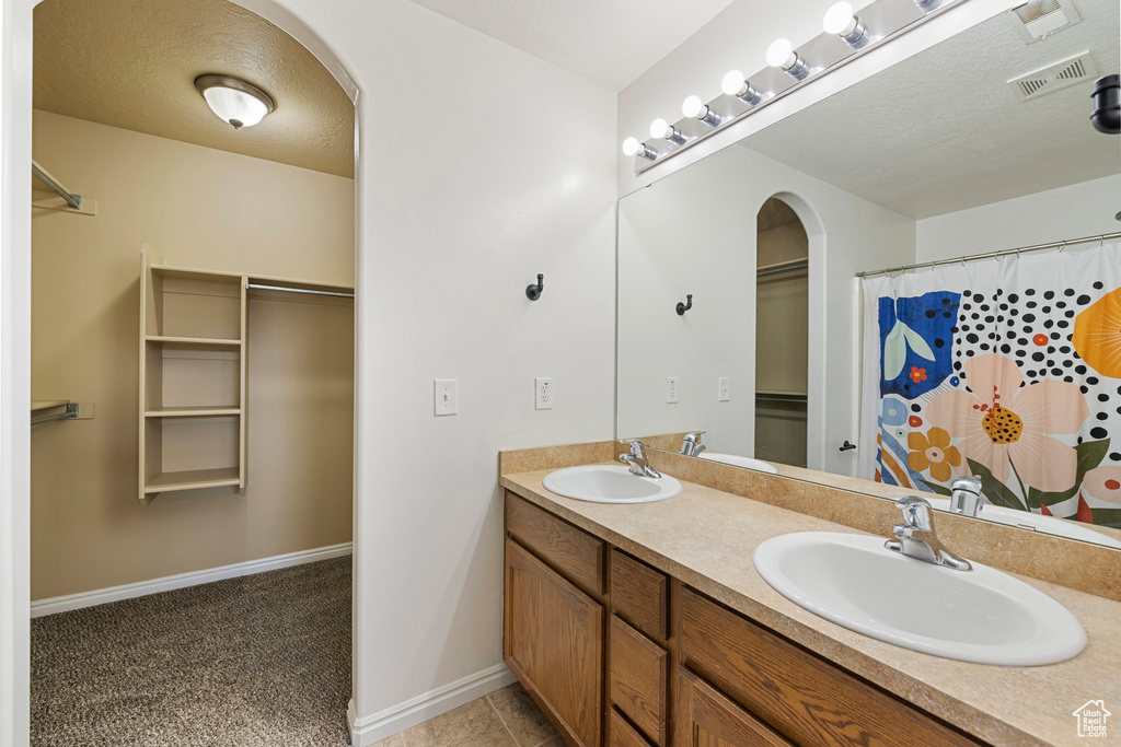 Full bath featuring double vanity and a shower with shower curtain