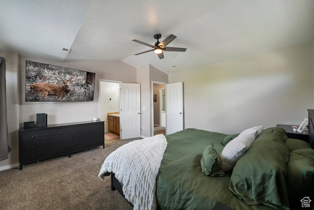 Carpeted bedroom with vaulted ceiling, ensuite bath, a ceiling fan, and baseboards