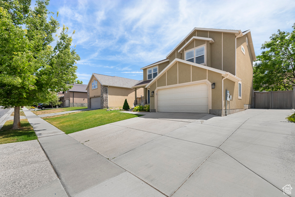 View of front facade with stucco siding and concrete driveway