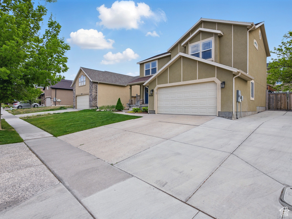 View of front facade featuring concrete driveway, stucco siding, and a garage