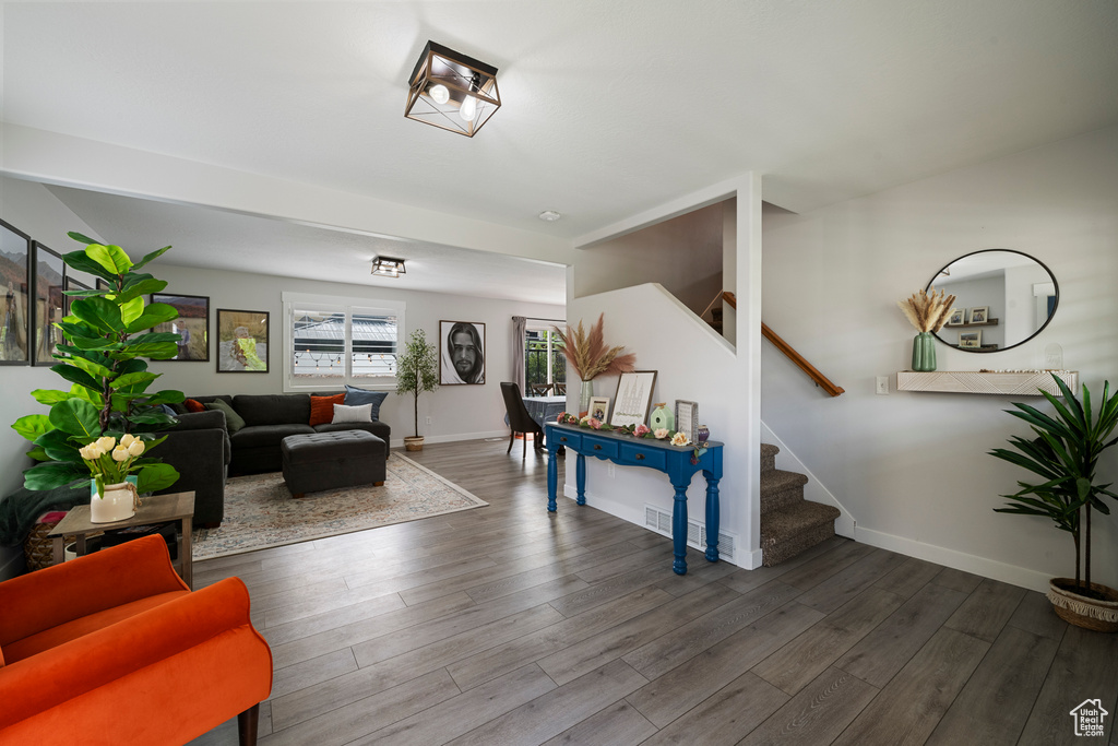 Living area featuring stairs, wood finished floors, and baseboards