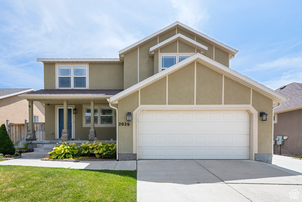 View of front of house with driveway, an attached garage, a porch, and stucco siding