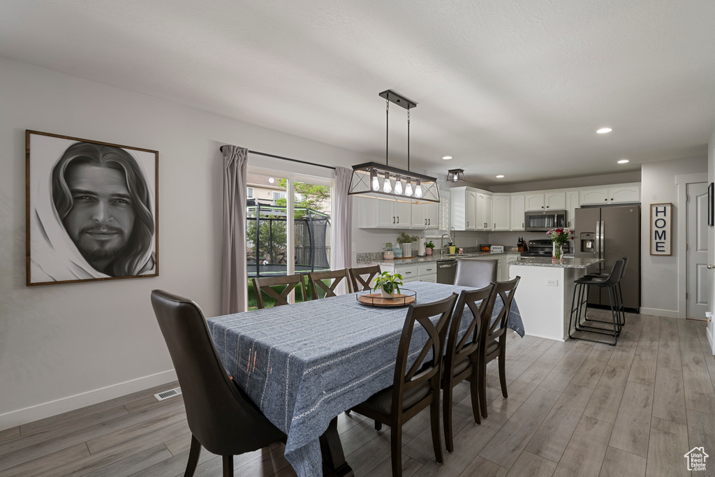Dining room featuring light wood-style flooring, baseboards, and recessed lighting