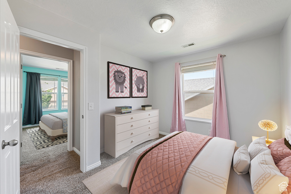 Carpeted bedroom with baseboards and a textured ceiling