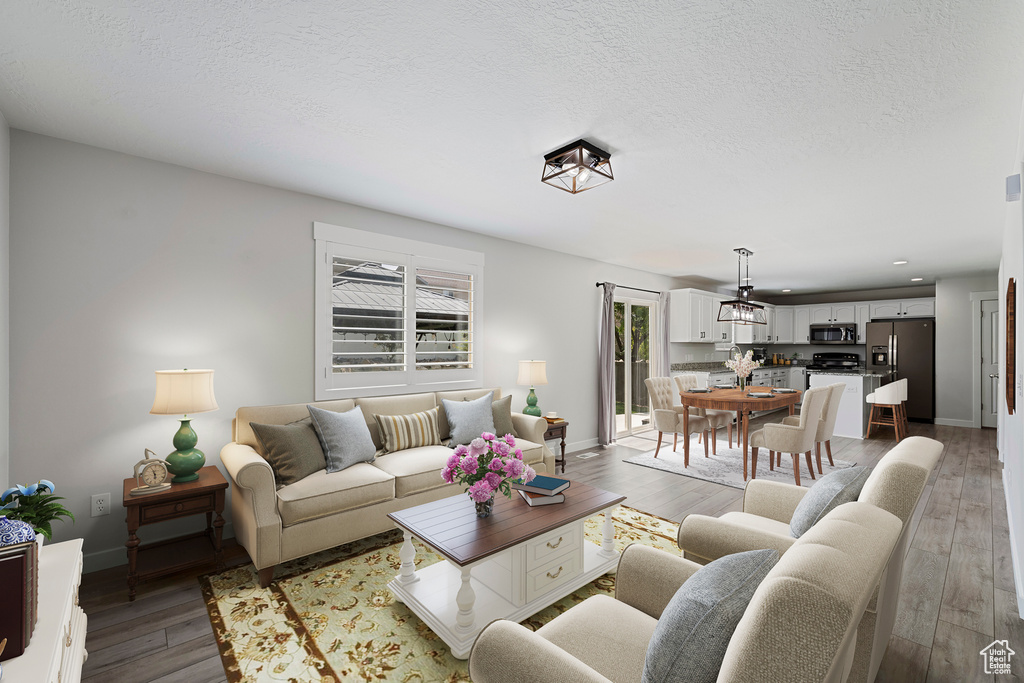 Living area featuring light wood-type flooring, recessed lighting, and a textured ceiling