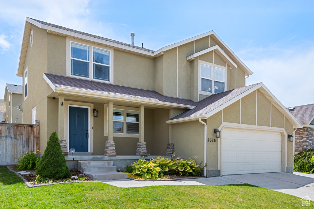 View of front of property with stucco siding, concrete driveway, a porch, and a garage