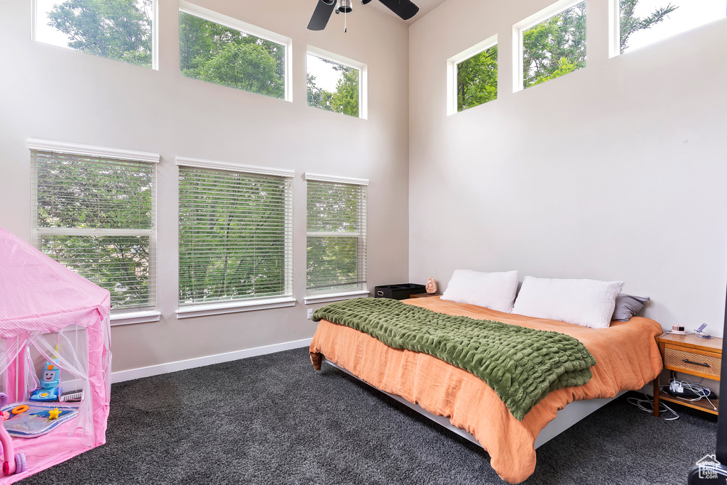 Carpeted bedroom with a high ceiling and baseboards