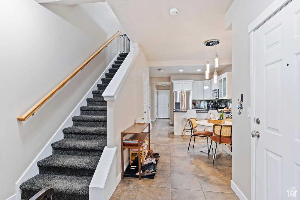 Stairway featuring baseboards and stone finish floors