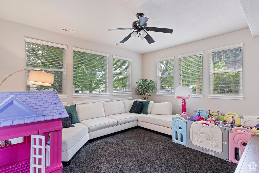 Carpeted living area with a ceiling fan