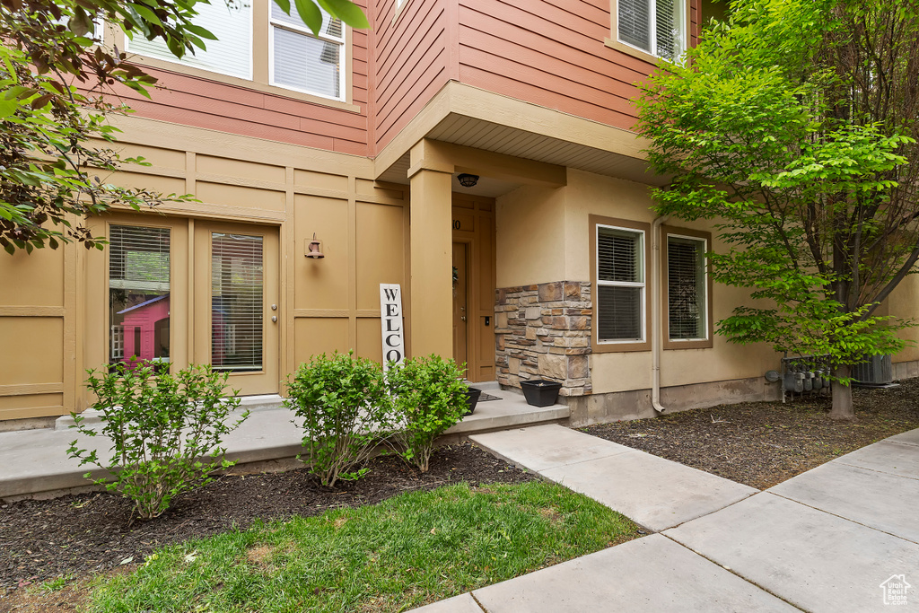 Entrance to property featuring stone siding and stucco siding