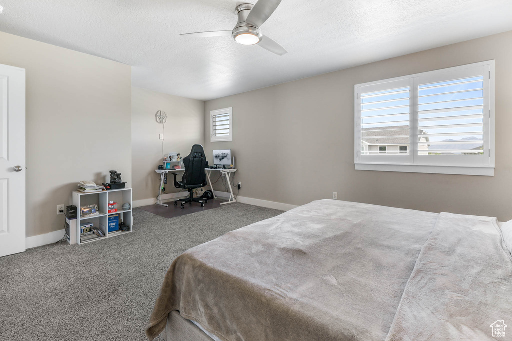 Bedroom featuring carpet flooring, baseboards, a textured ceiling, and ceiling fan