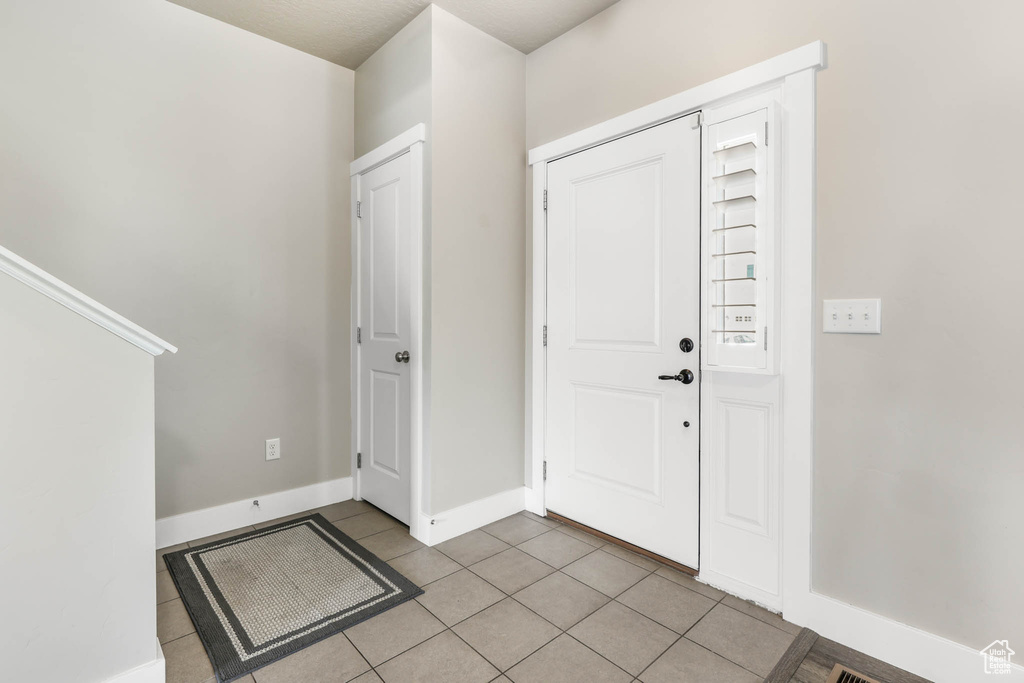 Entrance foyer featuring light tile patterned floors and baseboards