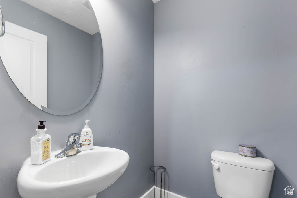 Bathroom with a sink, toilet, and baseboards