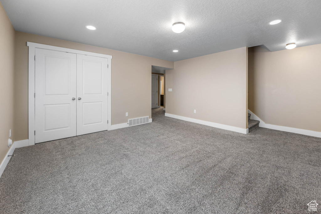 Unfurnished bedroom featuring a textured ceiling, baseboards, recessed lighting, carpet floors, and a closet