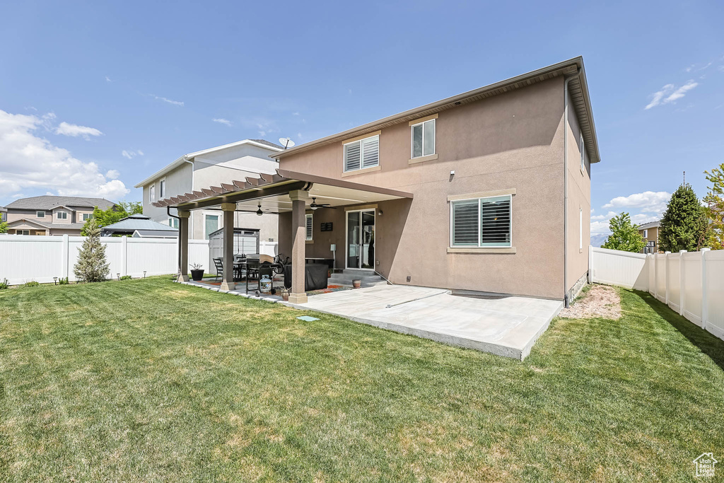 Back of house featuring a ceiling fan, a patio area, stucco siding, and a pergola