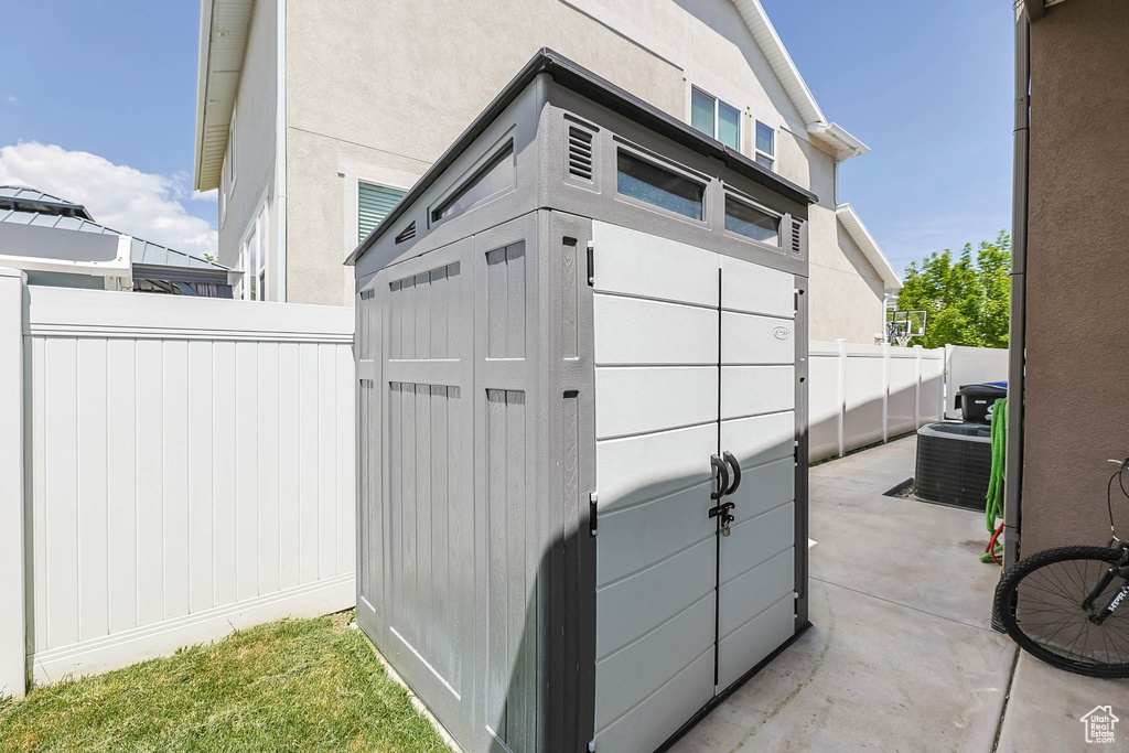 View of shed featuring fence and central air condition unit