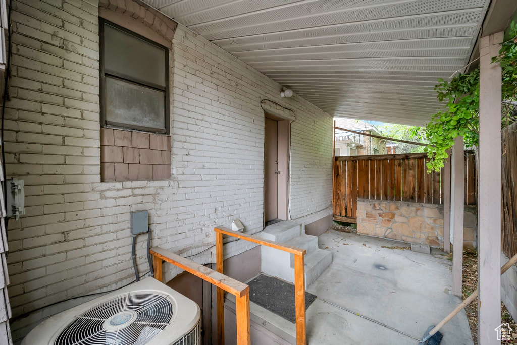 View of patio with fence and central AC unit