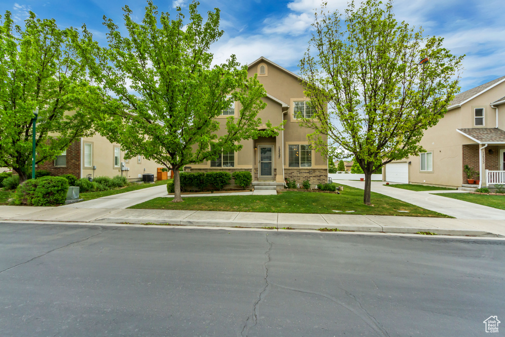 View of front facade with concrete driveway, stucco siding, and a garage