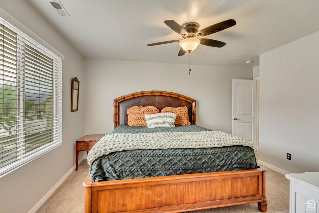 Bedroom featuring light colored carpet, multiple windows, and baseboards