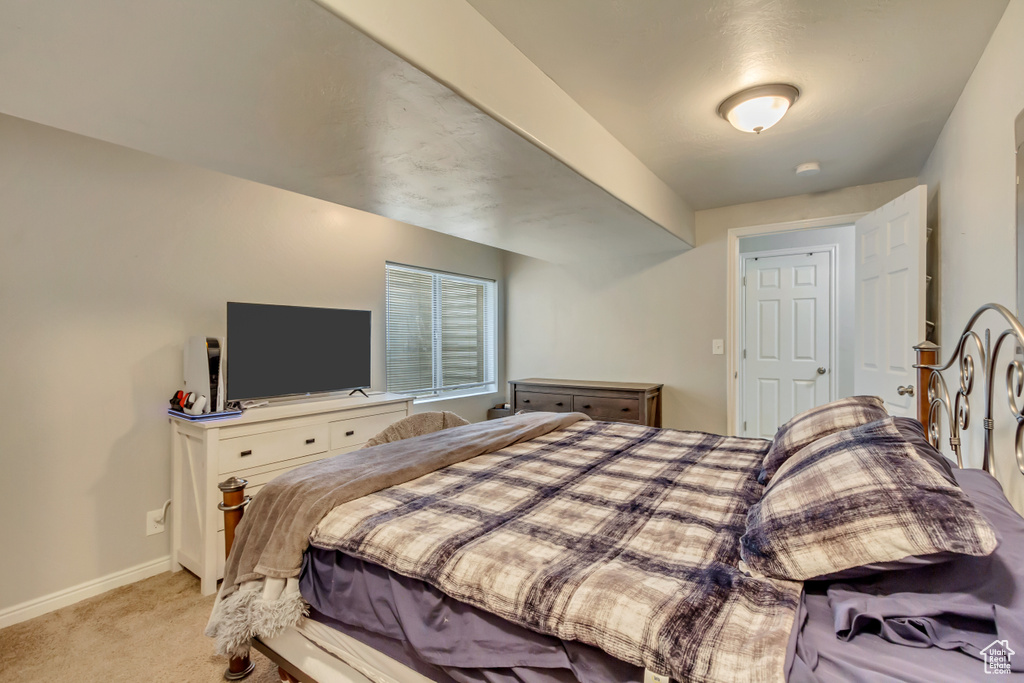 Bedroom featuring light carpet and baseboards