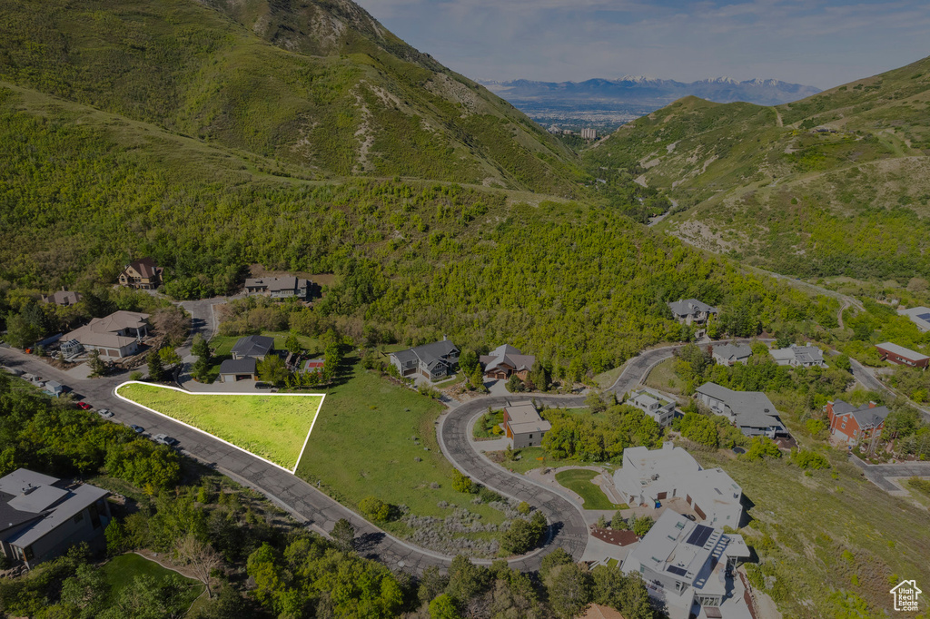 Aerial view of property and surrounding area with nearby suburban area and a mountainous background