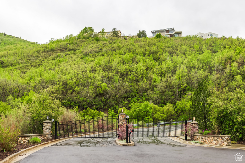 Surrounding community featuring a gate and a wooded view