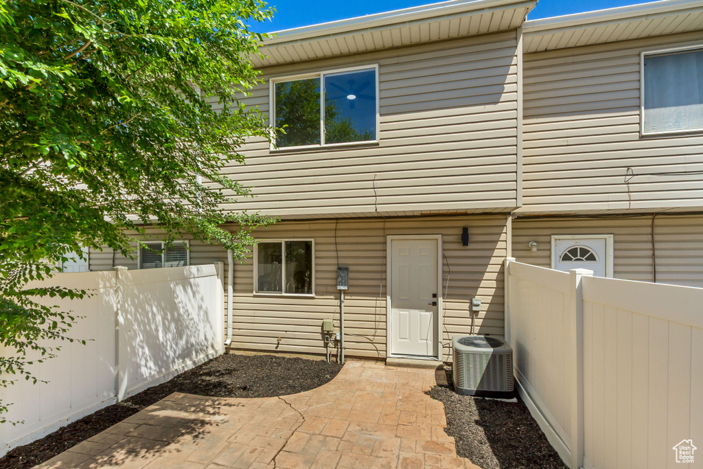 Back of property with fence, central AC, and a patio
